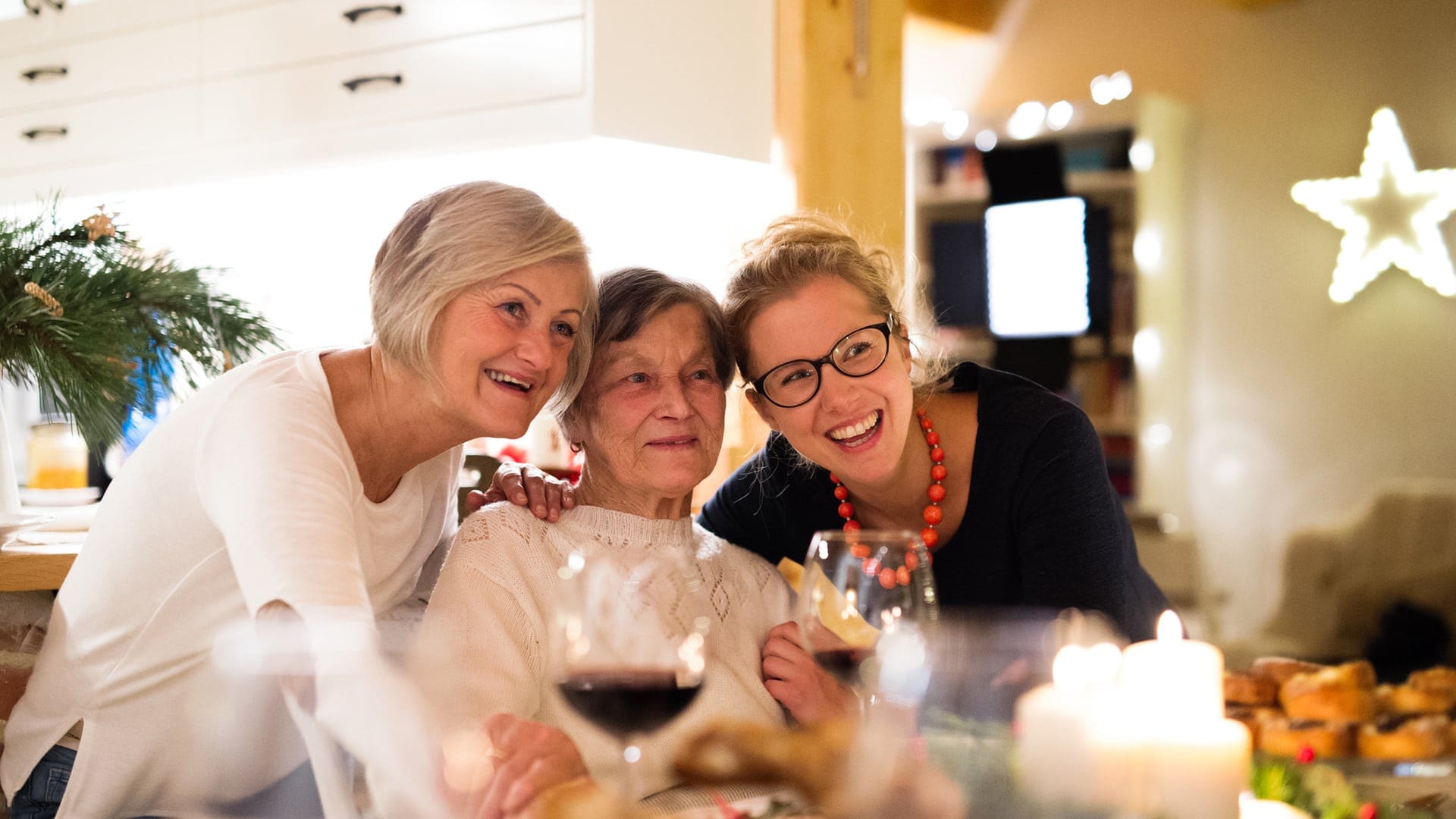 Three generations of women smiling together during a festive family visit at Charter Senior Living of Jefferson City, TN.
