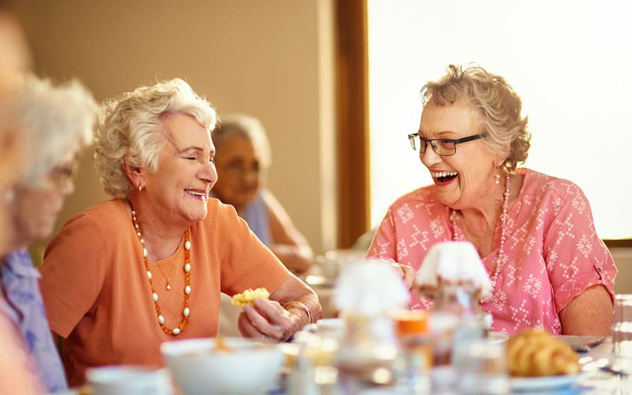 Group of senior women laughing and dining together at Charter Senior Living of Jefferson City, TN.