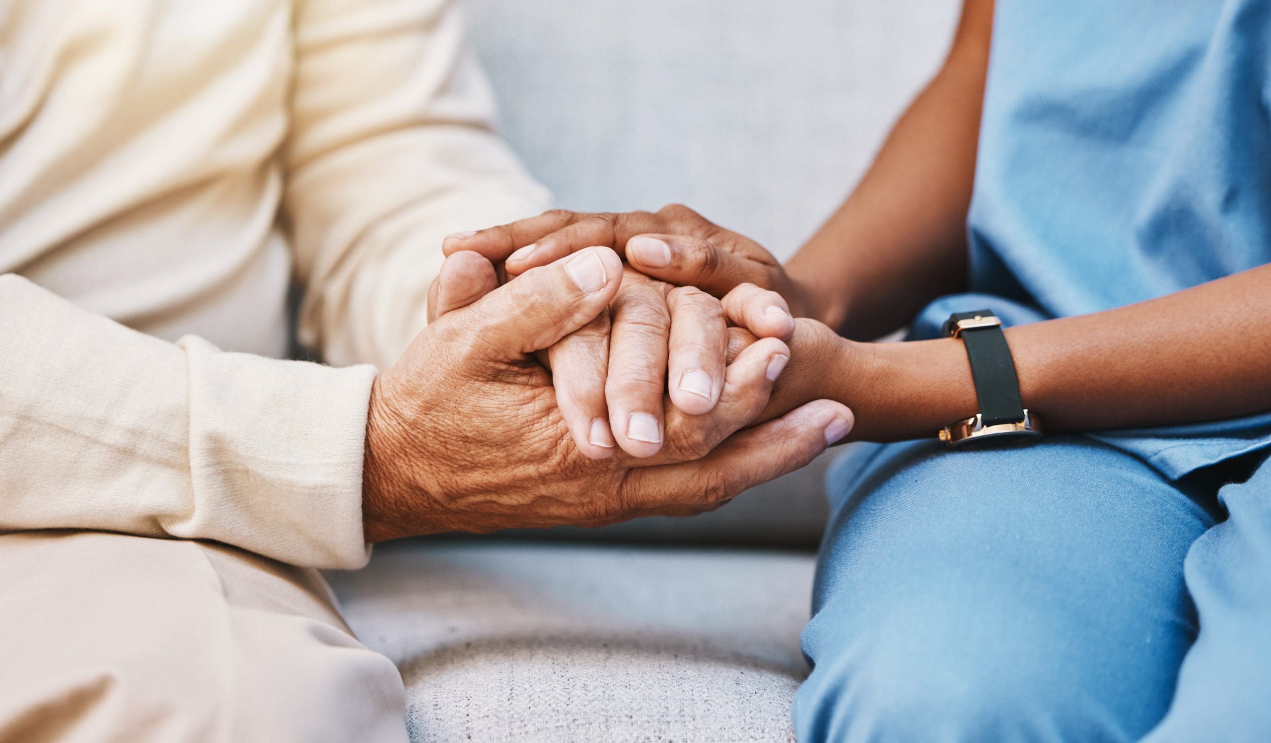 Close-up of caregiver holding hands with a resident, symbolizing compassionate support in Jefferson City, TN.